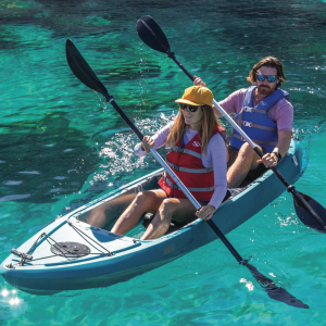 a group of people riding on the back of a boat in the water